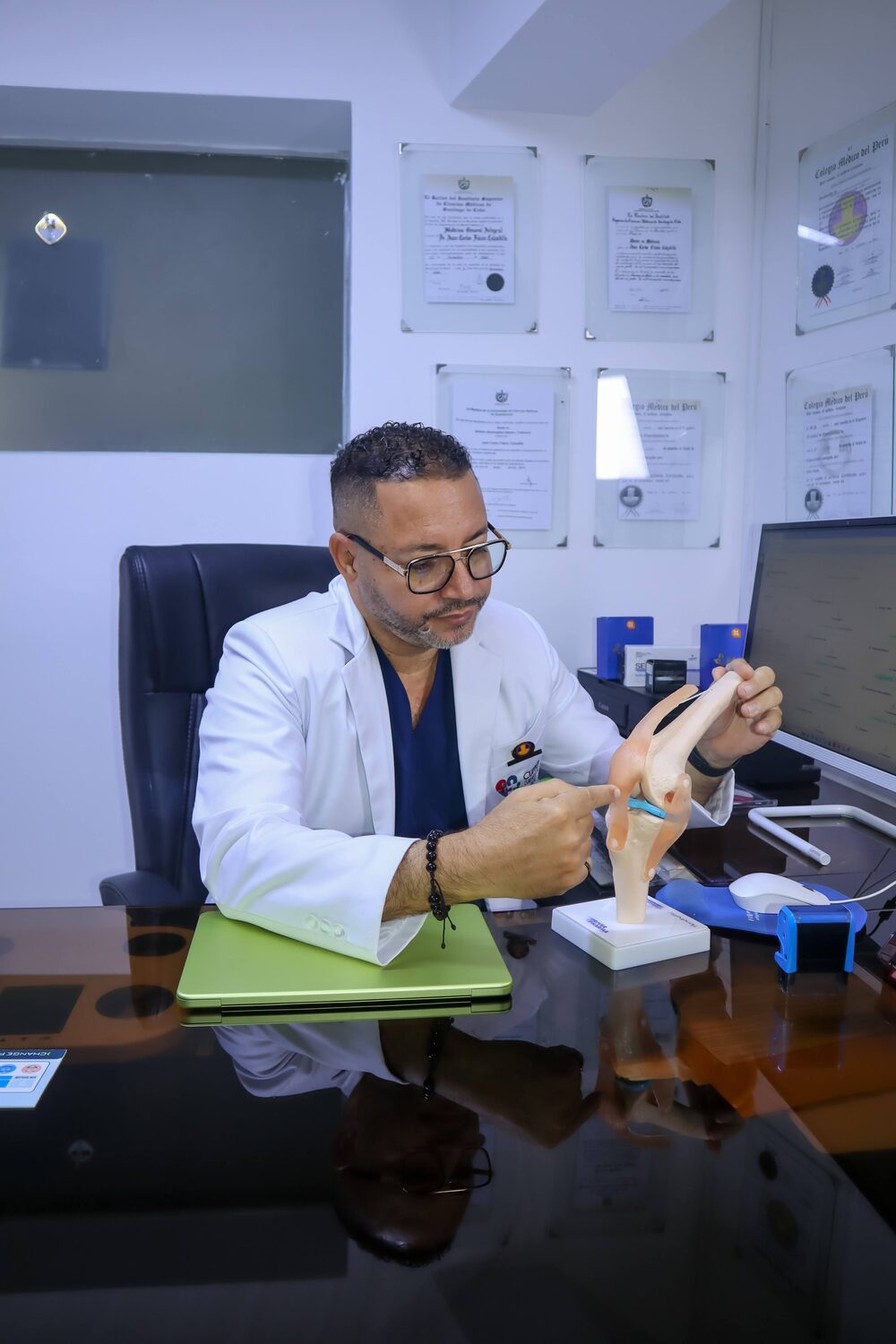 Dr. Falcón con modelo articular en consulta de medicina regenerativa